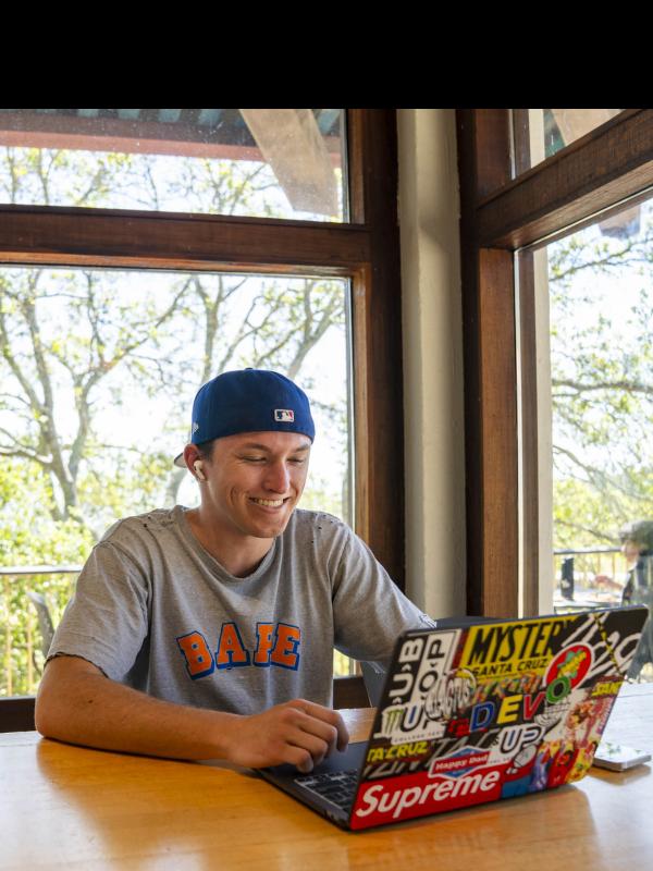 A student smiling at his computer