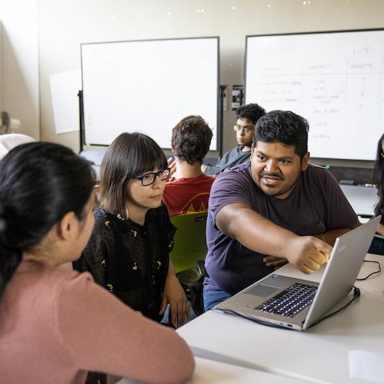 students and TA around a laptop