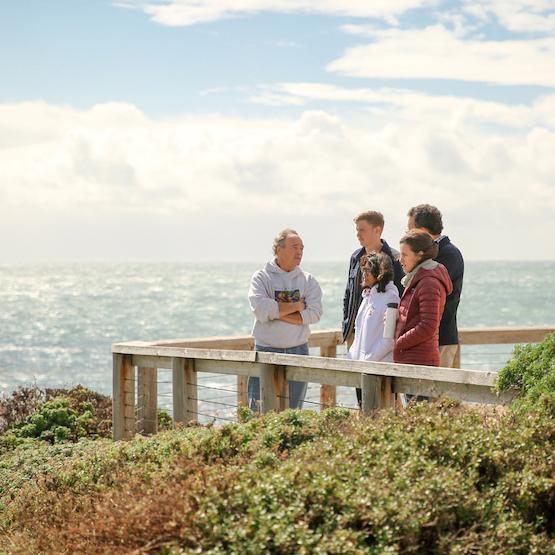 Professor with students ocean in background